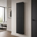 Black vertical flat single panel radiator mounted on a wall with slim vertical bars