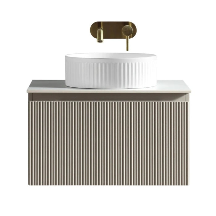 Vanity cabinet with ribbed front, white countertop sink, and brass taps