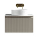 Vanity cabinet with ribbed front, white countertop sink, and brass taps