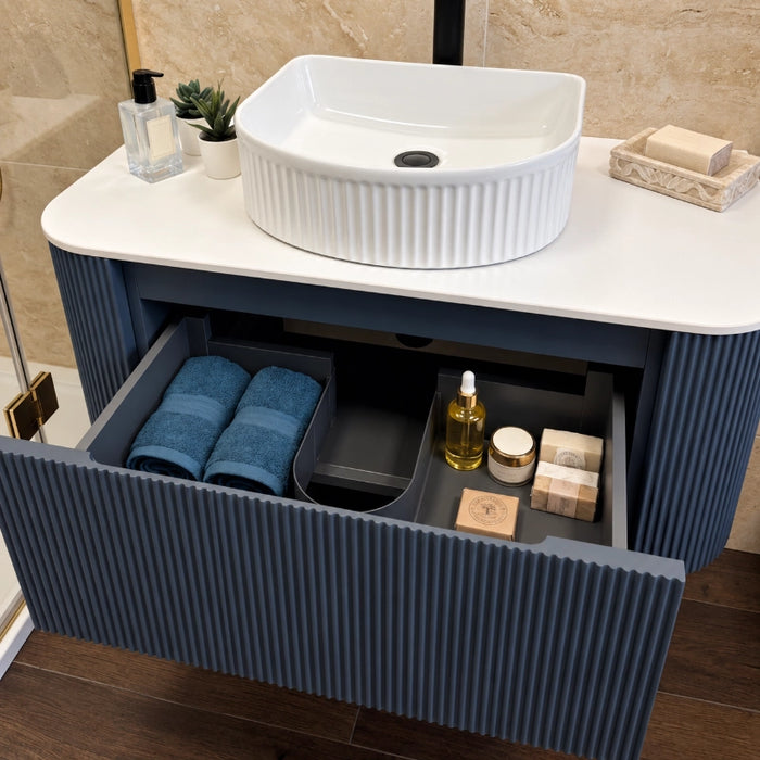 Fluted wall-hung corner vanity with round sink, white countertop, and open storage