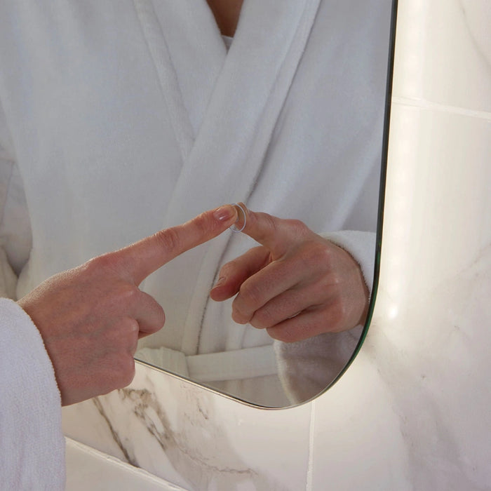 Rounded-rectangle bathroom mirror edge with reflective glass, shown being touched.