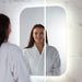 LED bathroom mirror with rounded-rectangle shape; person looks at their reflection.