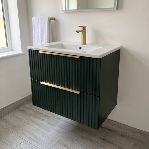 Forest green wall-hung vanity unit with white basin, brass tap, and ribbed cabinet doors.
