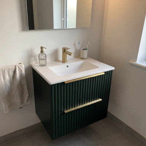 Forest green wall-hung vanity unit with square white basin and brushed brass bar handle.