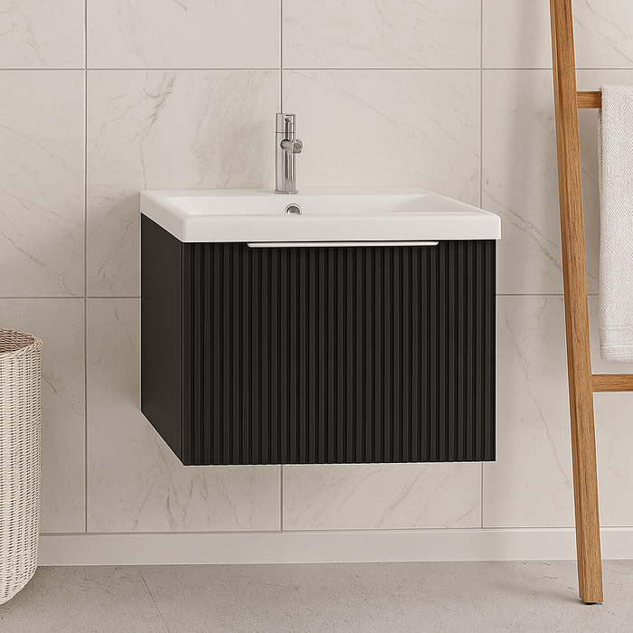 Bathroom vanity with black cabinet and white sink against a tiled wall.
