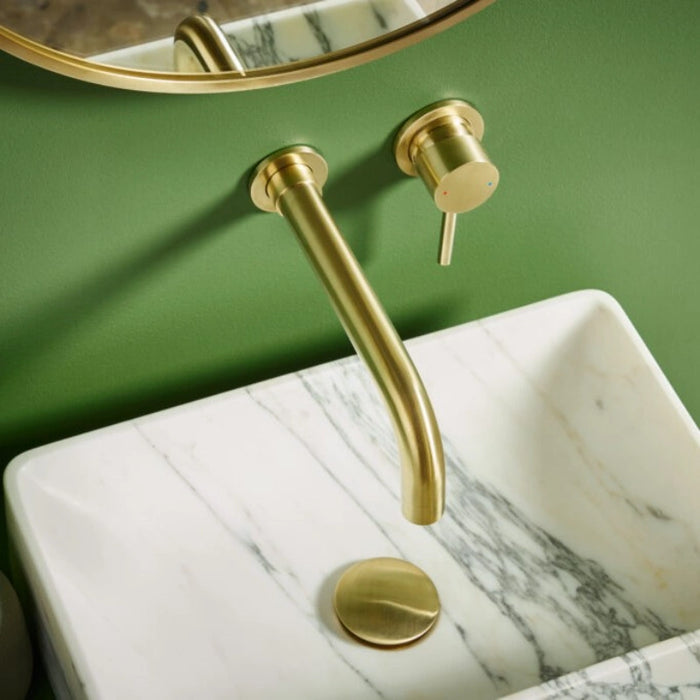 Brushed brass wall-mounted basin tap with tall spout and two small lever controls
