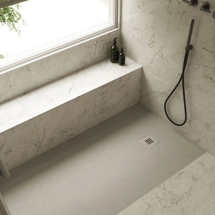 White rectangular shower tray with square waste drain in shower corner