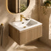 Wall-mounted vanity with white basin, country oak fluted cabinet and brass mixer tap